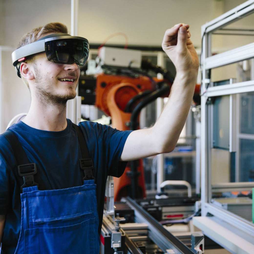 387445 Man / student werkt met AR bril op. Virtual reality in een productieomgeving.
