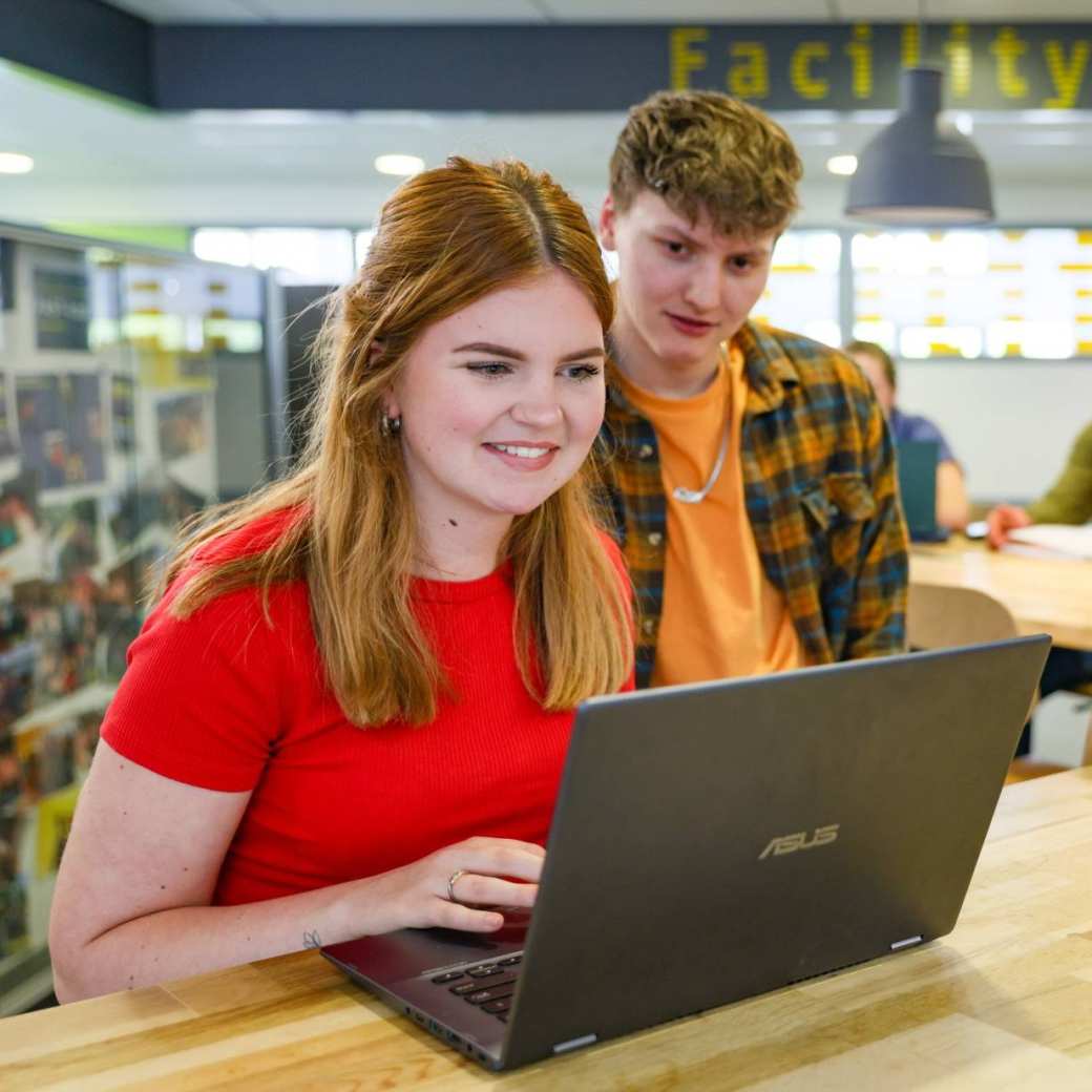 Twee studenten kijken naar een laptop