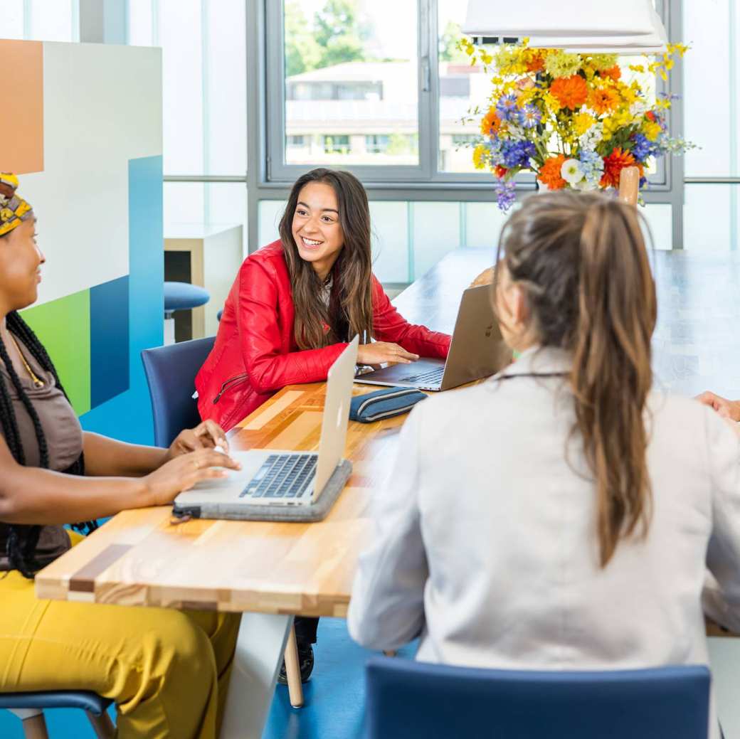 347963 Lo-res. Groep van 4 studenten in overleg aan tafel in algemene ruimte HAN. 