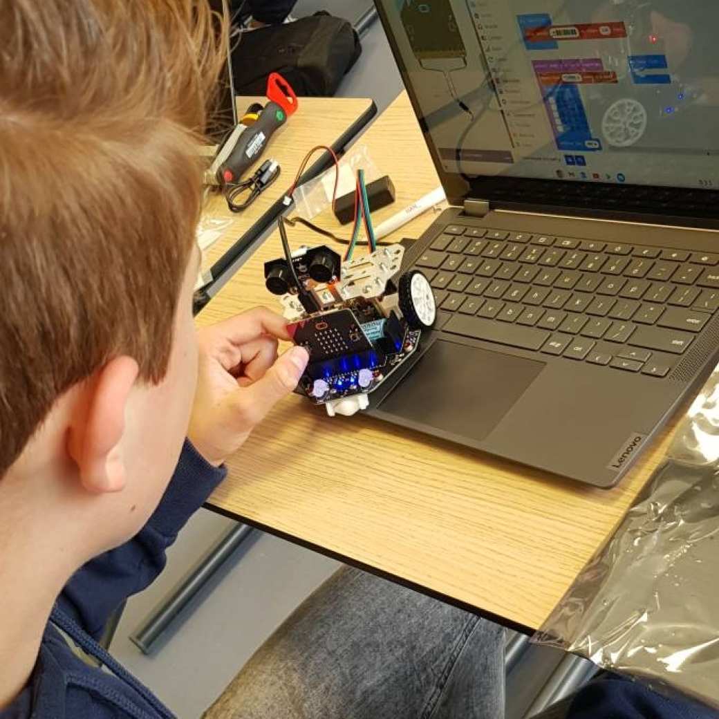 449305 Alex doet mee aan de workshop zelfrijdende robot programmeren met microbit tijdens Q-highschool op de HAN