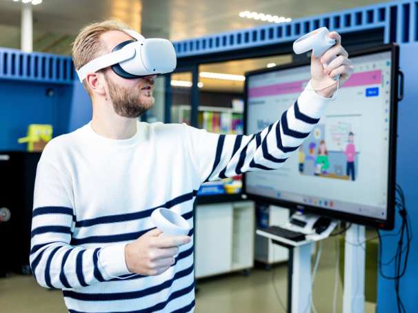 Jongen met VR-bril, doet simulatie laaggeletterdheid