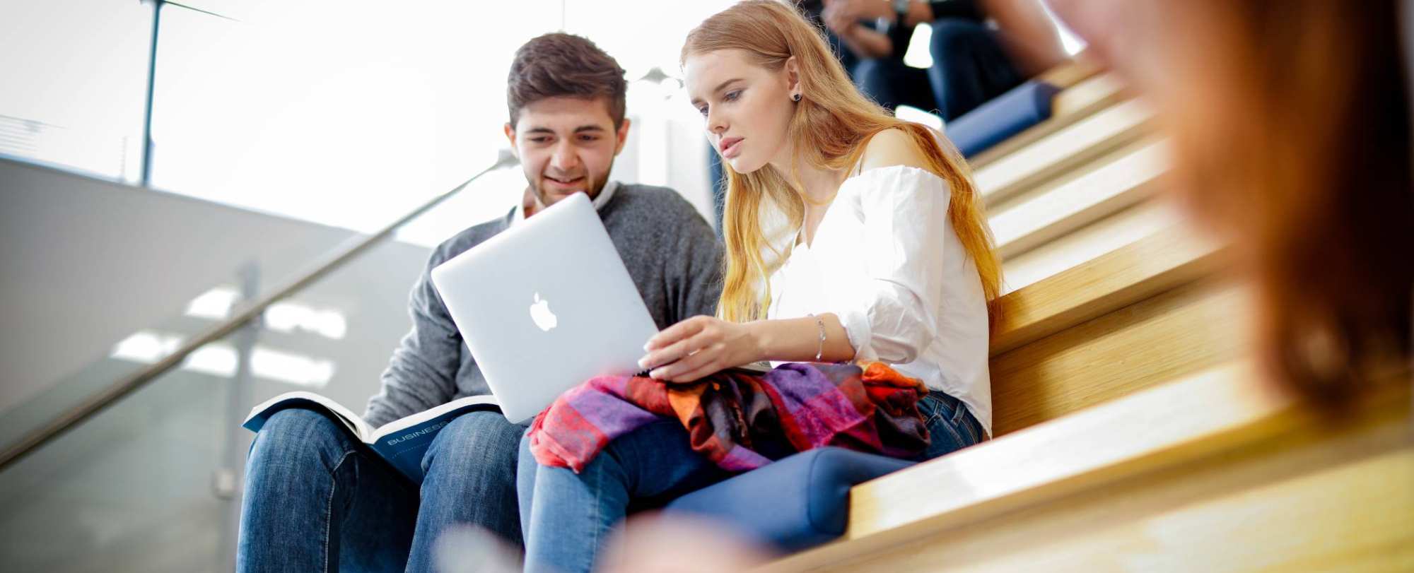 Twee studenten overleggen met laptop