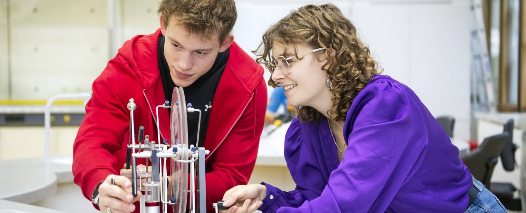 Twee studenten Leraar Natuurkunde kijken aandachtig naar hun experiment.