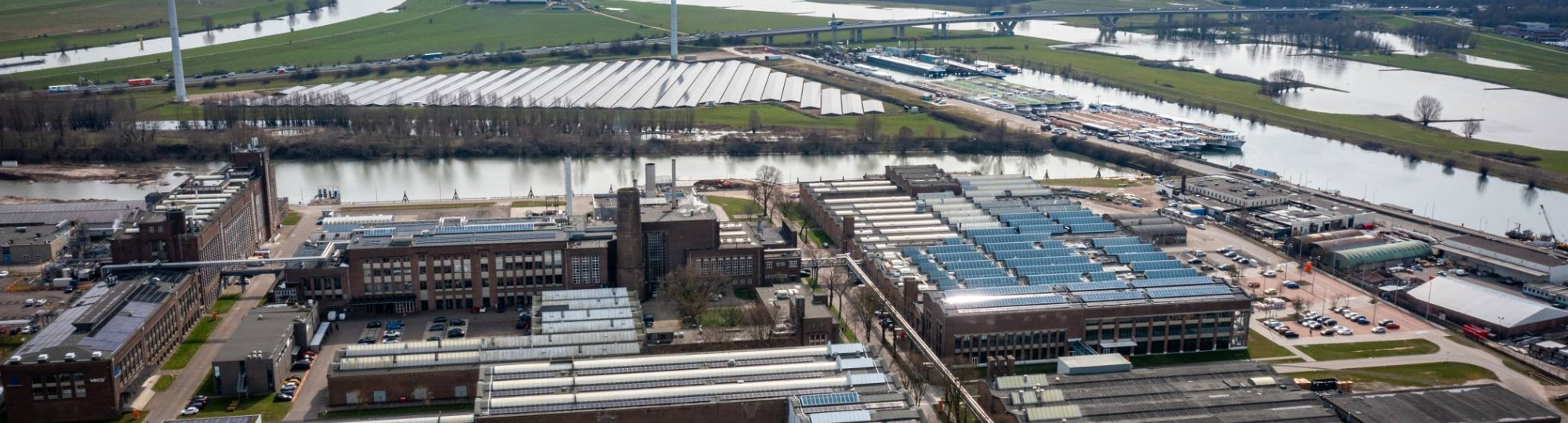 510432 Luchtfoto van het Industriepark Kleefse Waard (IPKW) met zonnepanelen. De Academie Engineering en Automotive werkt hier aan diverse projecten waaronder projecten met waterstof.