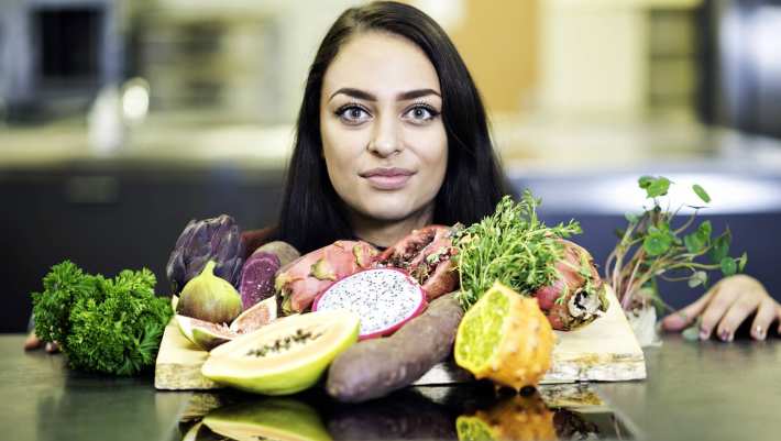 hoofd student scherp achter groente en fruit op tafel
