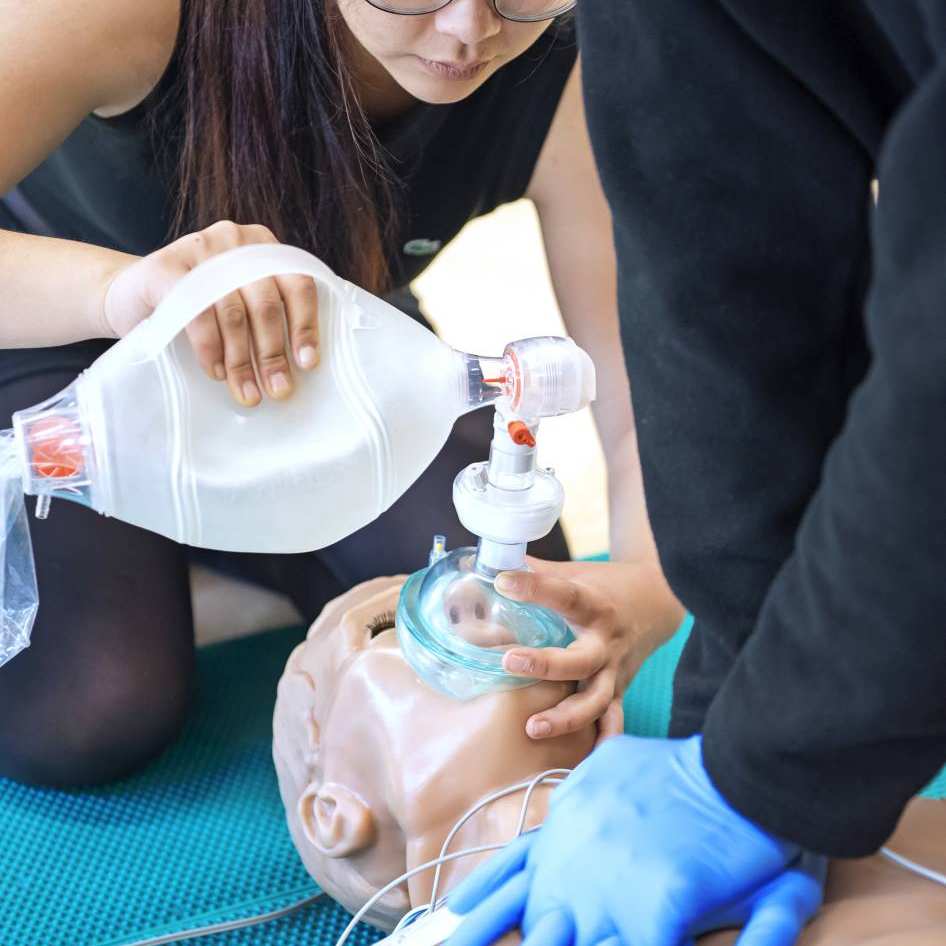 Studente Medische Hulpverlening beademt een pop tijdens een praktijkles