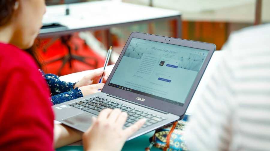 Student houdt laptop vast met Studielink pagina