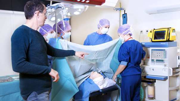 Medische Hulpverlening studenten oefenen met docent als operatieassistent in de operatiekamer