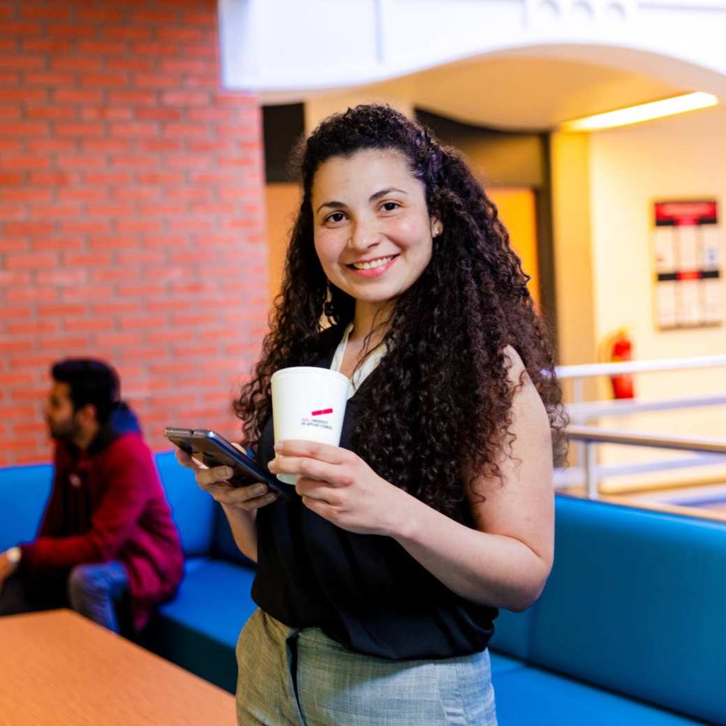 Een deeltijd student in Mens en Organisatie houdt pauze met een kopje koffie.