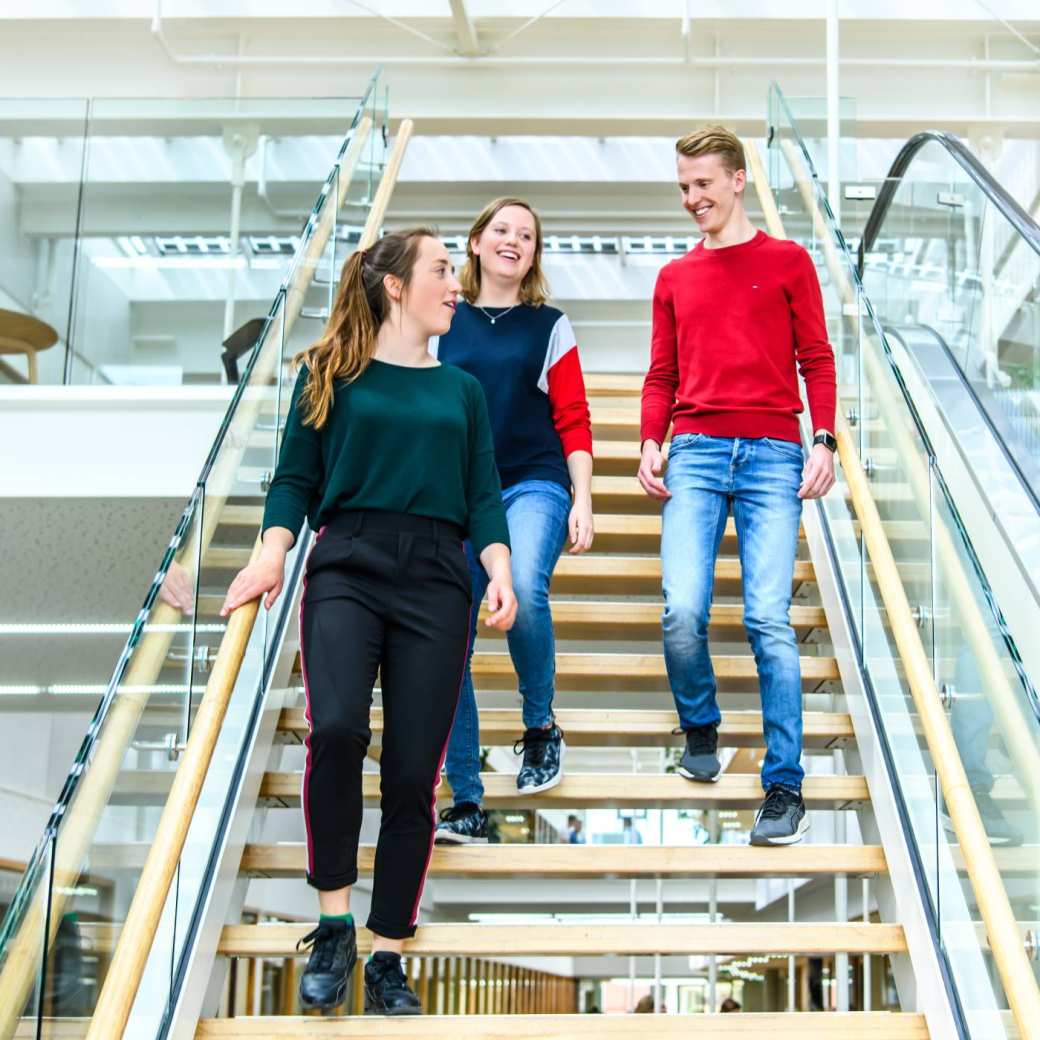 Drie studenten lopen de trap af in het I/O gebouw op de HAN campus in Nijmegen.