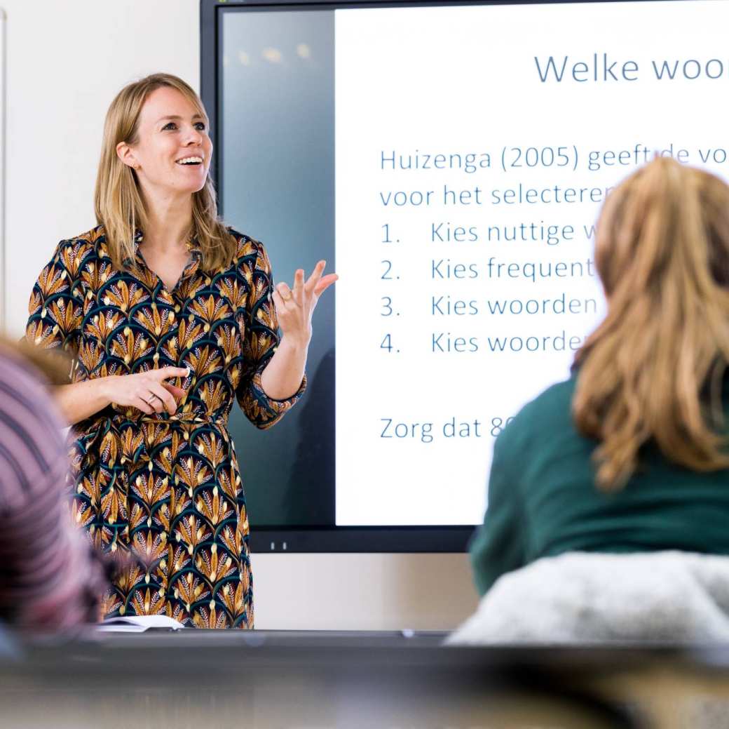 ALPO leraar staat voor de klas en telt op haar vingers