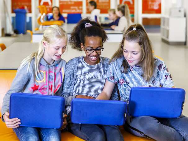 Drie studenten werken op laptop