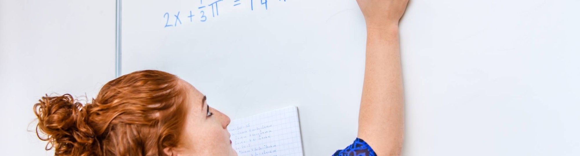 Wiskunde studente schrijft een wiskundige formule op het bord met een blauwe stift. 