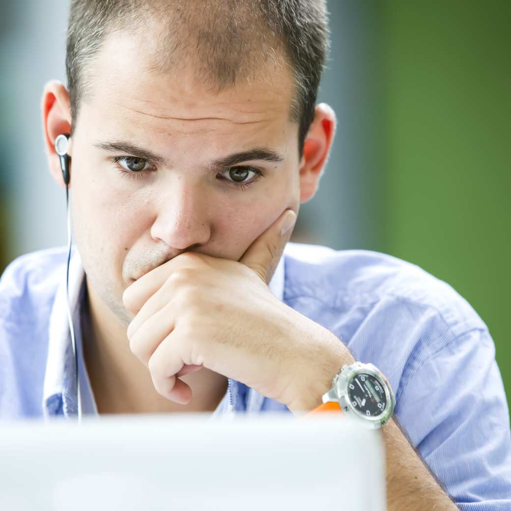 Een persoon kijkt geconcentreerd naar een laptop