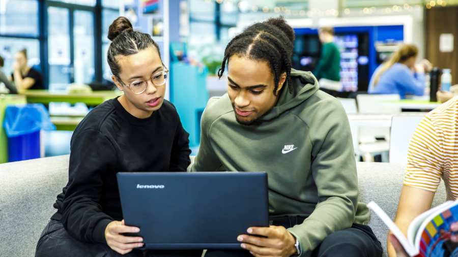 Studenten op bank samen naar laptop kijken