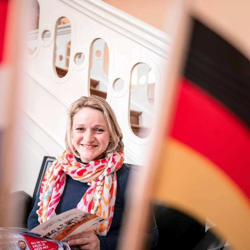 Student van de opleiding Leraar Duits achter een Nederlandse en Duitse vlag.