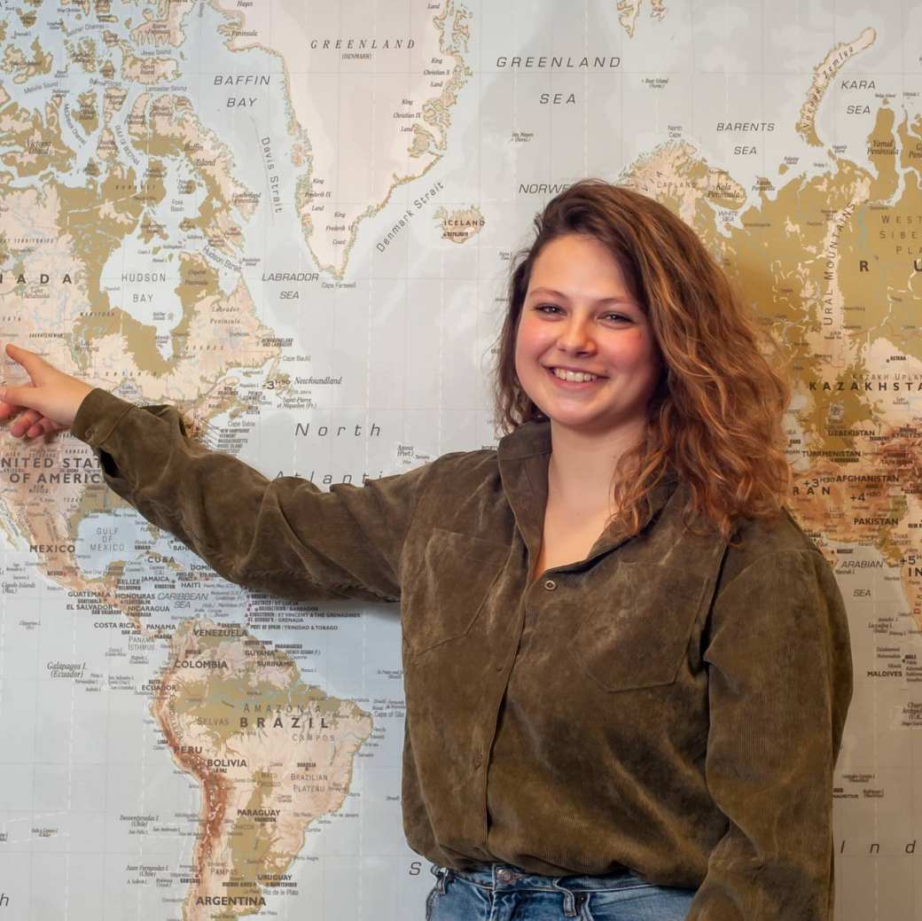 student Willemijn wijst amerika op wereldkaart aan