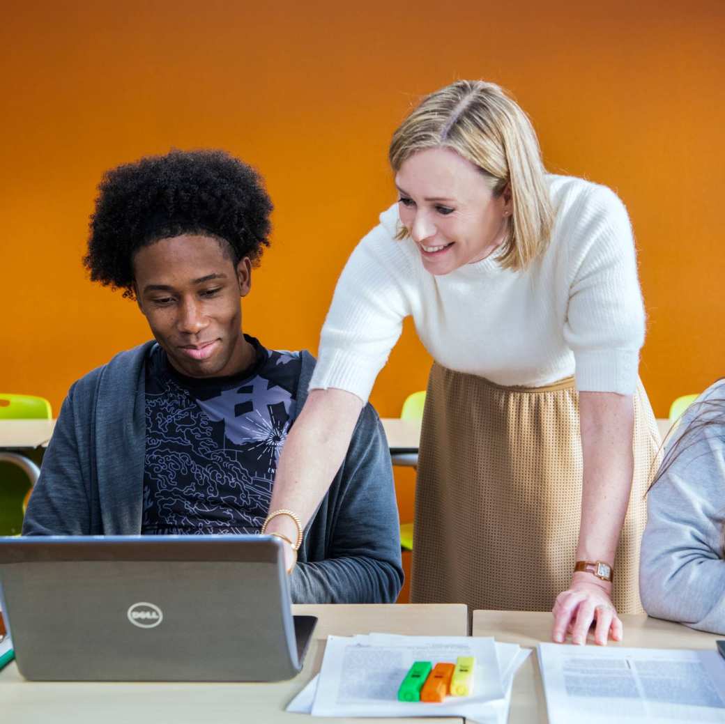 Docent legt masterstudenten Leraar Engels wat uit en wijst op laptopscherm