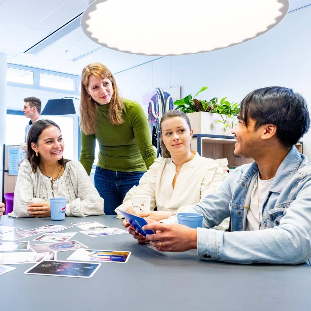 veel studenten in een hoorcollege zaal achter een laptop scherm