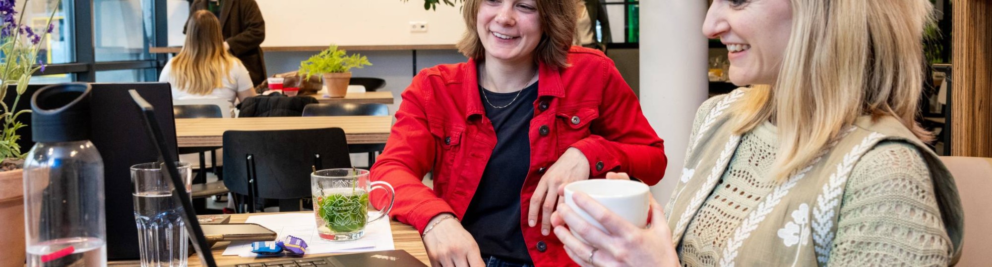 Bedrijfskunde deeltijd, studenten werken samen in de Hangar met laptops en koffie  