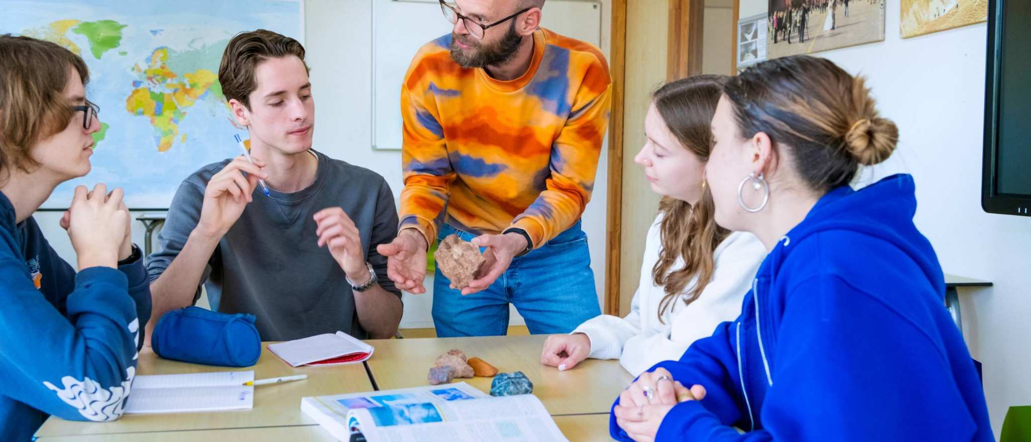 De leraar vertelt aan de studenten over een steen.