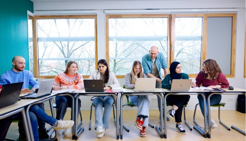 Pabo studenten zitten in de les en docent helpt