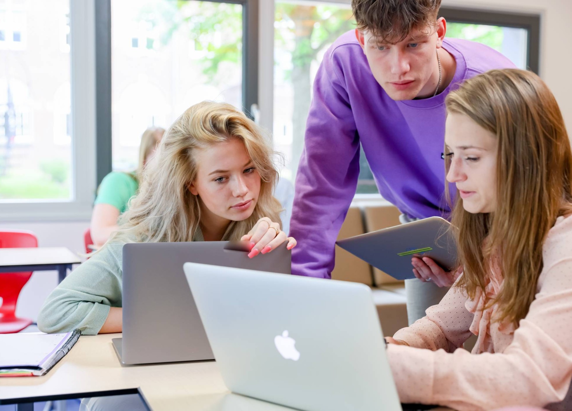 Studenten werken samen achter een laptop