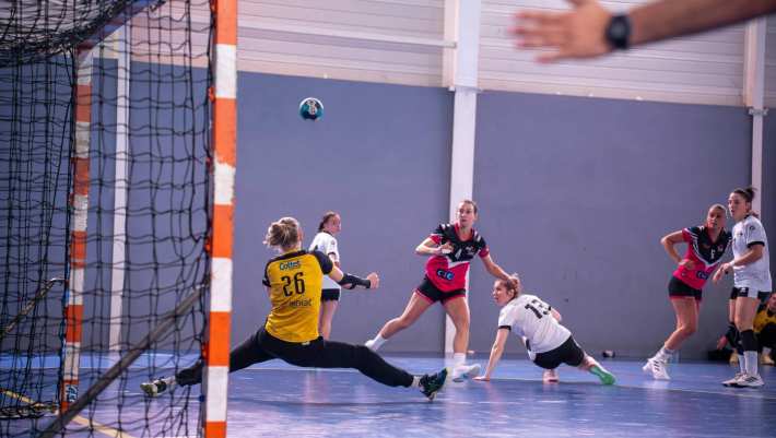 Headerbeeld, handbalwedstrijd. Keeper blokkeert een worp
