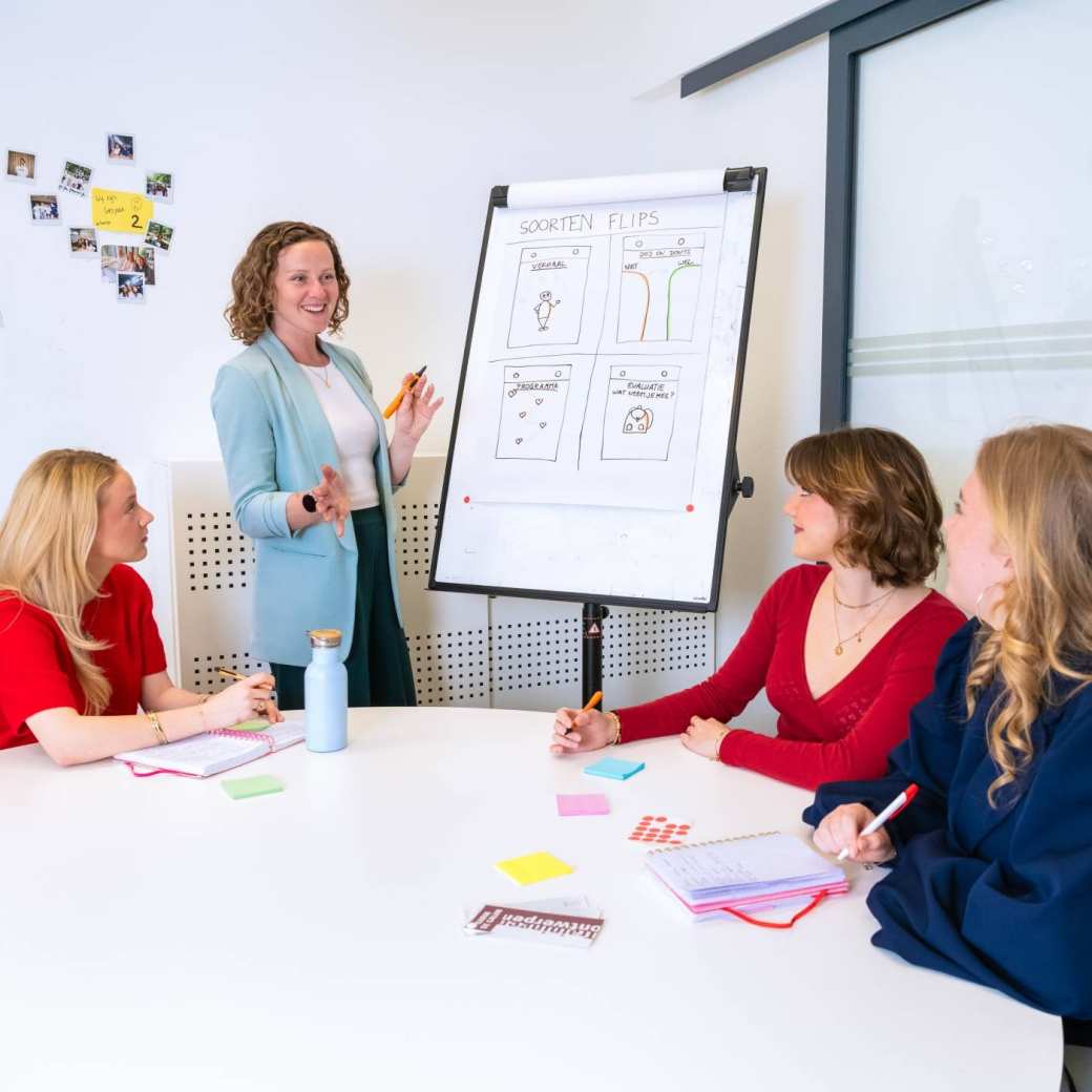 twee studenten van learning and development en een docent aan tafel