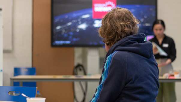 A student watches the game host explain a topic