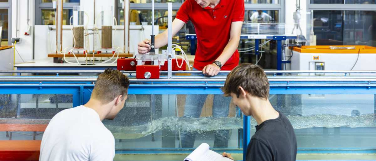 drie studenten simuleren in het waterlab situaties voor civiele techniek waterbouwkunde