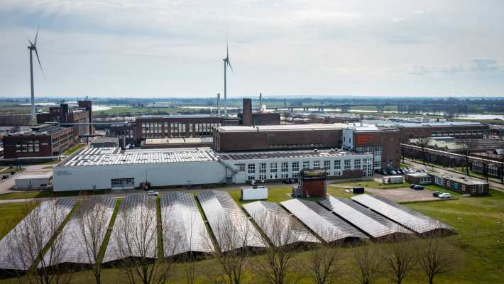Luchtfoto van het Industriepark Kleefse Waard (IPKW) met zonnepanelen en gebouwen. Academie Engineering en Automotive.