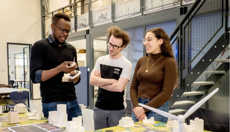 Docent geeft aan deeltijd studenten uitleg over de smart grid tafel van HAN Engineering en Automotive