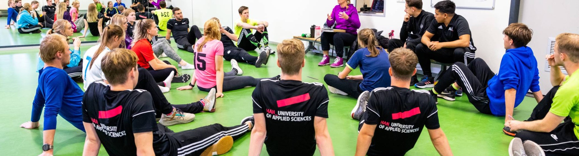 ALO-studenten luisteren naar docente tijdens sportles