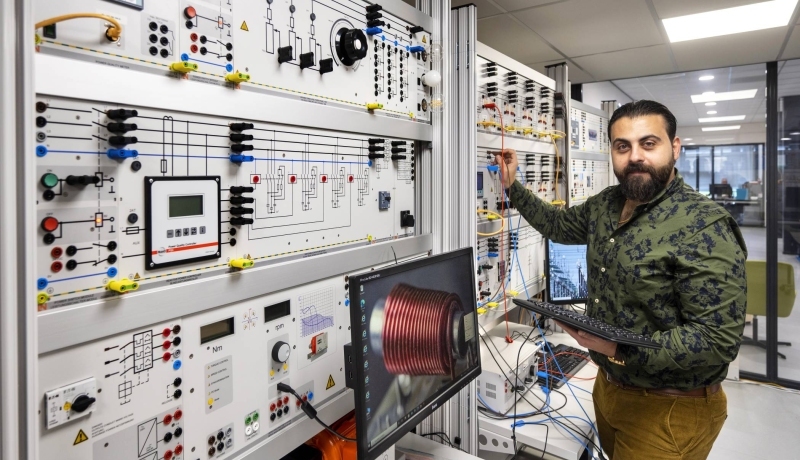 Orwa Al Bitar bij de knoppenkast.SEECE, SEE, HAN WATTS, Powerminor, deeltijd Elektrotechniek, Lectoraat Meet- en Regeltechniek, Lectoraat Duurzame Energie, Lectoraat Balanced Energy Systems.