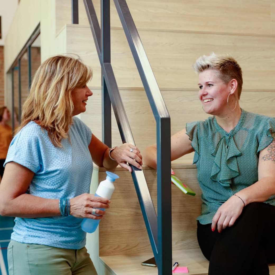 2 masterstudenten praten met elkaar bij de HAN.