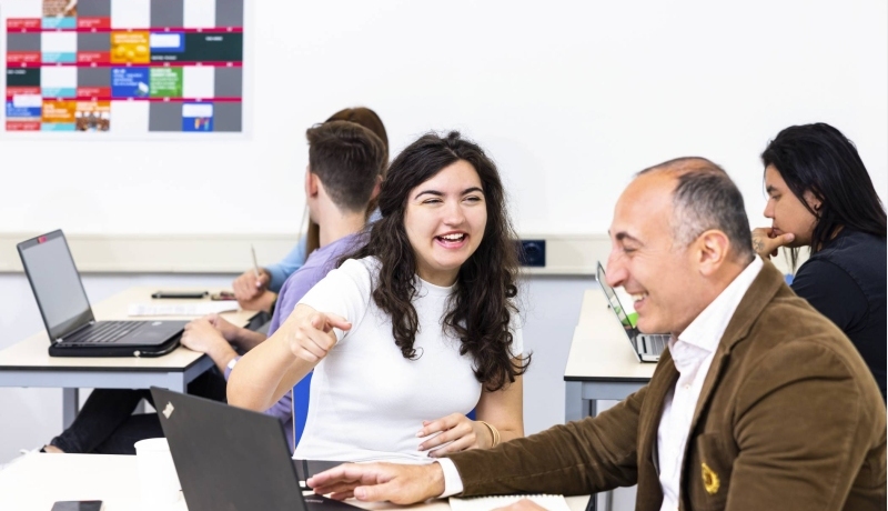 International Business-student krijgt begeleiding van een docent die vakkennis deelt.