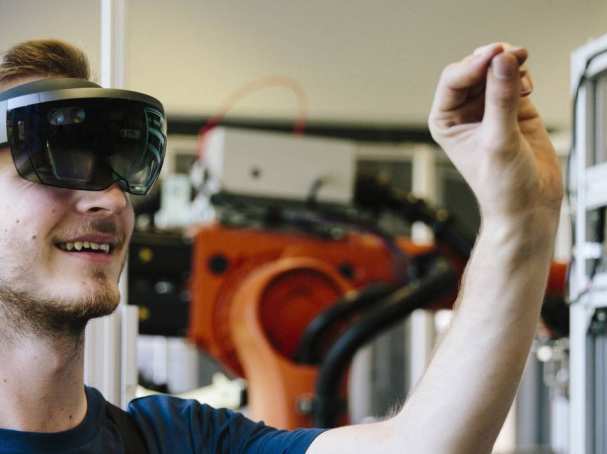 Man / student werkt met AR bril op. Virtual reality in een productieomgeving