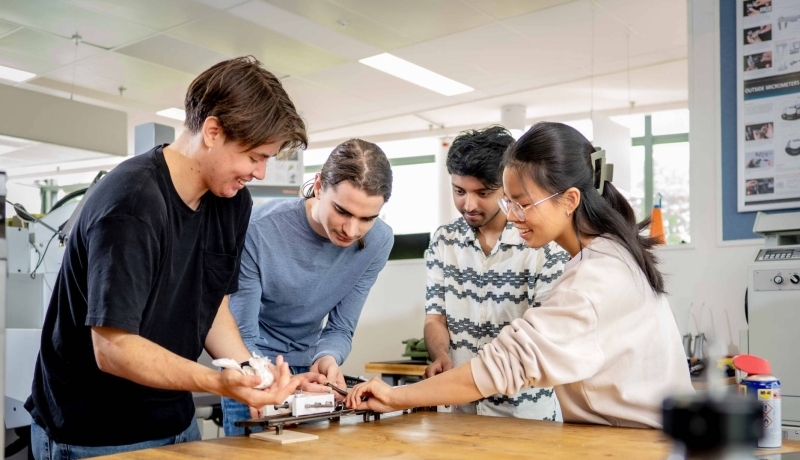 Studenten werktuigbouwkunde moeten samenwerken bij het op spanning brengen van een veer.