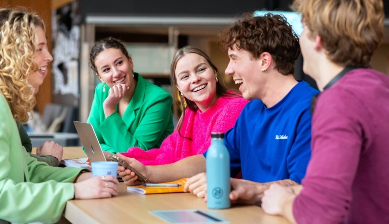 Studenten lachen naar elkaar. 
