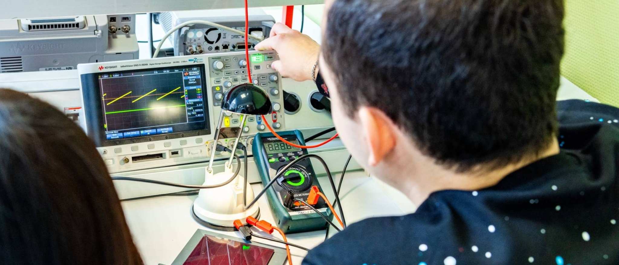 Twee studenten elektrotechniek doen een experiment met een zonnepaneel.