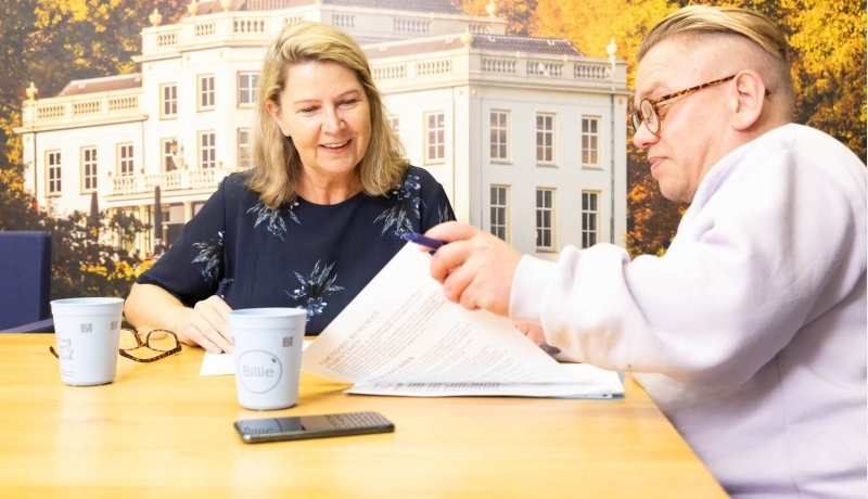 2 mensen aan een tafel met een vel papier voor hun neus