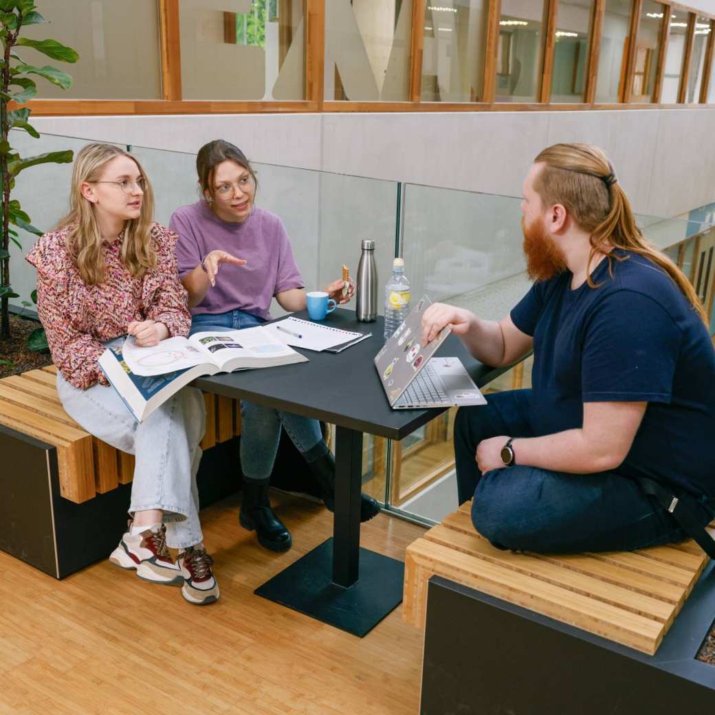 Docent scheikunde legt groepje studenten iets uit