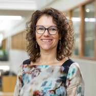 Portretfoto Kirsten de Ries, gebloemde jurk dragend