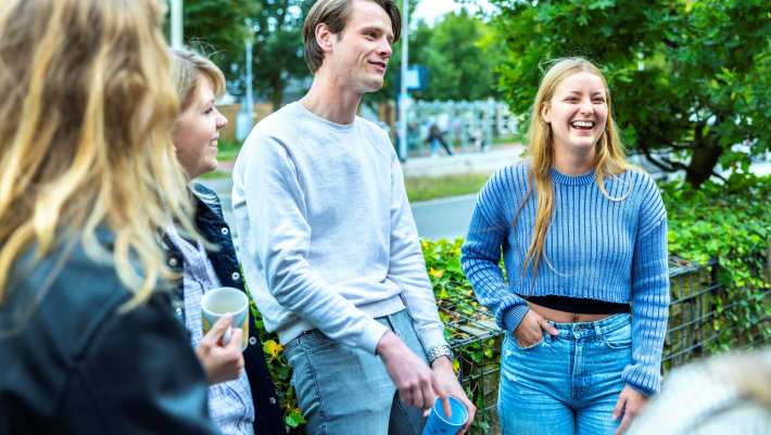 Een groep studenten HAN Social Work zijn samen buiten in gesprek. 