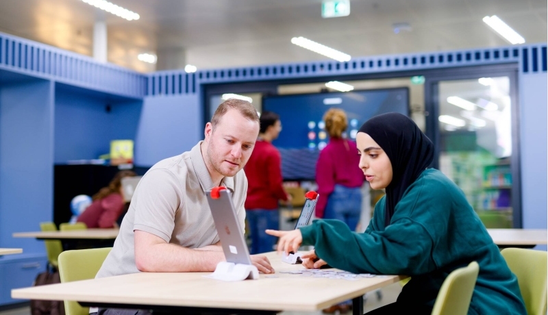 Studenten zitten in het iXperium en werken op een iPad