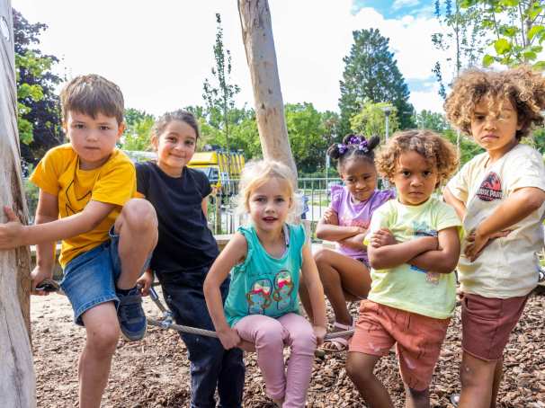 Zes kinderen poseren tijdens het buitenspelen op het klimrek. Foto van de opleiding leraar basisonderwijs