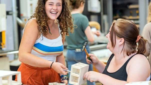 Twee studenten Beeldende Therapie lachen en werken in een praktijklokaal
