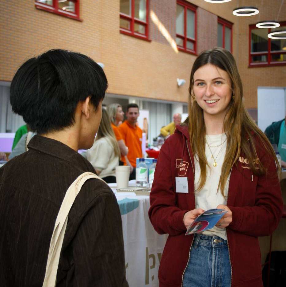 twee studenten in gesprek tijdens de Netwerkmarkt van AOO op 9 maart 2026