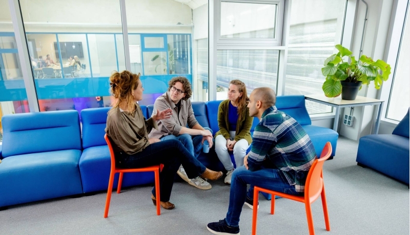 Twee studenten schaterlachen met elkaar.